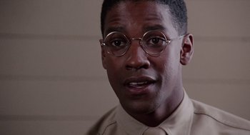 Movie still from “A Soldier's Story” (1984), directed by Norman Jewison – A person wearing glasses and a shirt; Close Up shot, Over the shoulder angle