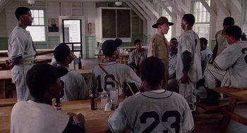 Movie still from “A Soldier's Story” (1984), directed by Norman Jewison – A group of baseball players sitting around a table; Wide shot, Over the shoulder angle