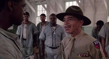 Movie still from “A Soldier's Story” (1984), directed by Norman Jewison – A group of men standing next to each other in a room; Medium shot, Low angle