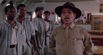 Movie still from “A Soldier's Story” (1984), directed by Norman Jewison – A group of men standing next to each other in a room; Medium shot, Low angle