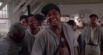 Movie still from “A Soldier's Story” (1984), directed by Norman Jewison – A group of men standing next to each other laughing; Medium shot, Low angle