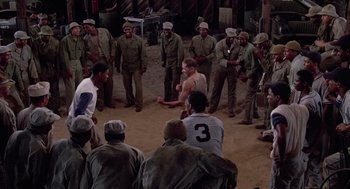 Movie still from “A Soldier's Story” (1984), directed by Norman Jewison – A group of men standing around in a circle; Wide shot, High angle