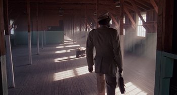 Movie still from “A Soldier's Story” (1984), directed by Norman Jewison – A man in a suit and hat is walking in a building; Wide shot, Low angle