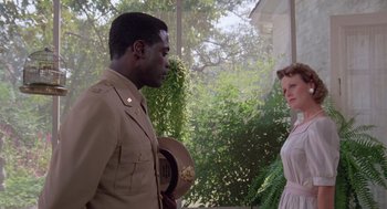 Movie still from “A Soldier's Story” (1984), directed by Norman Jewison – A man in a military uniform talking to a woman in a white dress; Medium shot, Low angle