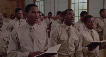 Movie still from “A Soldier's Story” (1984), directed by Norman Jewison – A group of men standing next to each other in a room; Medium shot, Low angle