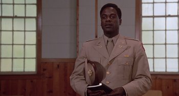 Movie still from “A Soldier's Story” (1984), directed by Norman Jewison – A man in a military uniform holding a book; Medium shot, Low angle