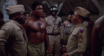Movie still from “A Soldier's Story” (1984), directed by Norman Jewison – A group of men standing next to each other in a room; Medium shot, Low angle