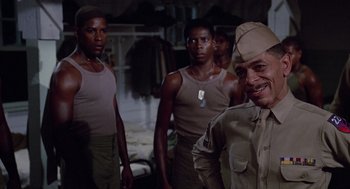 Movie still from “A Soldier's Story” (1984), directed by Norman Jewison – A group of men standing next to each other in a room; Medium shot, Low angle