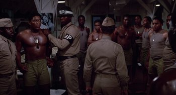 Movie still from “A Soldier's Story” (1984), directed by Norman Jewison – A group of men standing in a room together; Medium shot, Over the shoulder angle