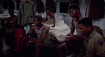 Movie still from “A Soldier's Story” (1984), directed by Norman Jewison – A group of men sitting on a bed in a room; Medium shot, High angle