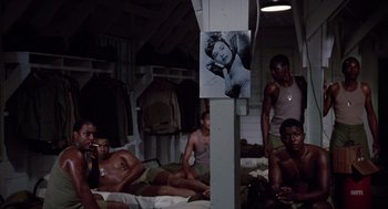 Movie still from “A Soldier's Story” (1984), directed by Norman Jewison – A group of men sitting on top of mattresses; Medium shot, High angle
