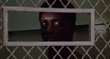Movie still from “A Soldier's Story” (1984), directed by Norman Jewison – A man looking through the bars of a jail cell; Close Up shot, Low angle