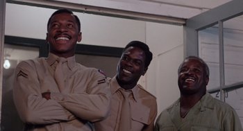 Movie still from “A Soldier's Story” (1984), directed by Norman Jewison – A group of men in uniform smiling for a picture; Medium shot, Low angle