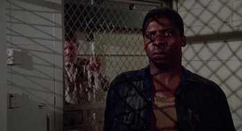 Movie still from “A Soldier's Story” (1984), directed by Norman Jewison – A man standing in front of a jail cell; Close Up shot, Over the shoulder angle