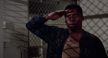 Movie still from “A Soldier's Story” (1984), directed by Norman Jewison – A man saluting in front of a window; Medium shot, Low angle