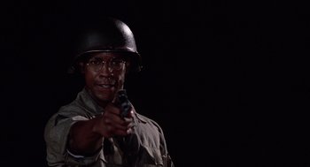 Movie still from “A Soldier's Story” (1984), directed by Norman Jewison – An african american man wearing a helmet and holding a gun; Close Up shot, Low angle