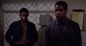 Movie still from “A Soldier's Story” (1984), directed by Norman Jewison – Two men standing next to each other in a dark room; Close Up shot, Low angle