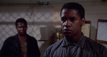 Movie still from “A Soldier's Story” (1984), directed by Norman Jewison – A young man standing next to another man in a kitchen; Close Up shot, Low angle