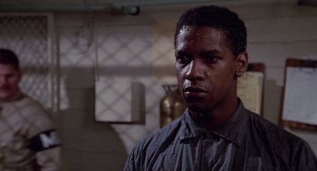 Movie still from “A Soldier's Story” (1984), directed by Norman Jewison – A man in a gray shirt is looking at the camera; Close Up shot, Low angle