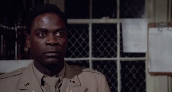 Movie still from “A Soldier's Story” (1984), directed by Norman Jewison – A man in a uniform is standing in front of a window; Close Up shot, Low angle