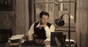 Movie still from “A Special Day” (1977), directed by Ettore Scola – A man sitting in front of a computer desk; Medium shot, High angle