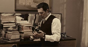 Movie still from “A Special Day” (1977), directed by Ettore Scola – A man in a vest and tie looking at a camera; Medium shot, Low angle