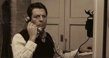 Movie still from “A Special Day” (1977), directed by Ettore Scola – A man sitting at a desk holding a phone to his ear; Close Up shot, High angle