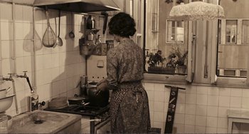 Movie still from “A Special Day” (1977), directed by Ettore Scola – A woman in an apron cooking in a kitchen; Medium shot, High angle