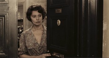 Movie still from “A Special Day” (1977), directed by Ettore Scola – A woman standing in front of an open door; Medium shot, High angle