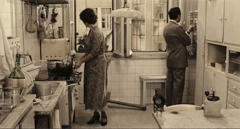 Movie still from “A Special Day” (1977), directed by Ettore Scola – An old photo of a woman and a man standing in a kitchen; Wide shot, High angle