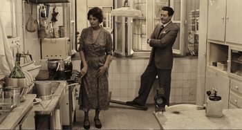Movie still from “A Special Day” (1977), directed by Ettore Scola – A man and a woman standing in a kitchen next to each other; Wide shot, High angle