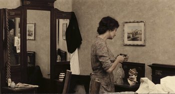 Movie still from “A Special Day” (1977), directed by Ettore Scola – A woman standing in front of a mirror holding a cell phone; Medium shot, High angle