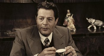 Movie still from “A Special Day” (1977), directed by Ettore Scola – A man in a suit holding a cup of coffee; Close Up shot, Over the shoulder angle