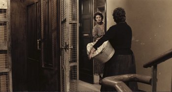 Movie still from “A Special Day” (1977), directed by Ettore Scola – An old photo of a woman holding a large bucket; Wide shot, High angle