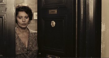 Movie still from “A Special Day” (1977), directed by Ettore Scola – A woman standing in front of a black door; Medium shot, Low angle