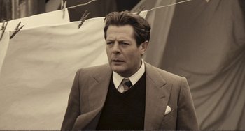 Movie still from “A Special Day” (1977), directed by Ettore Scola – A man in a suit and tie standing next to a clothesline; Close Up shot, Low angle