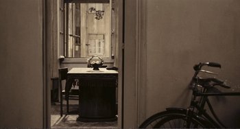 Movie still from “A Special Day” (1977), directed by Ettore Scola – An old photo of a room with a table and chairs; Wide shot, High angle