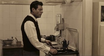 Movie still from “A Special Day” (1977), directed by Ettore Scola – A man standing in front of a stove holding a knife; Medium shot, Low angle