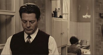 Movie still from “A Special Day” (1977), directed by Ettore Scola – A man wearing a vest and tie in a room; Medium shot, Over the shoulder angle