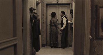 Movie still from “A Special Day” (1977), directed by Ettore Scola – A man and a woman standing in front of an open door; Wide shot, High angle