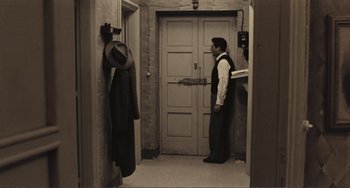 Movie still from “A Special Day” (1977), directed by Ettore Scola – A man standing in front of an open door; Wide shot, High angle