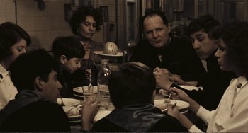 Movie still from “A Special Day” (1977), directed by Ettore Scola – A group of people sitting around a table eating food; Medium shot, Over the shoulder angle
