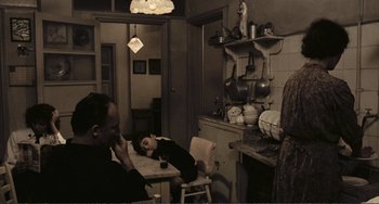 Movie still from “A Special Day” (1977), directed by Ettore Scola – A man and a woman sitting at a table in a kitchen; Wide shot, High angle