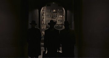 Movie still from “A Special Day” (1977), directed by Ettore Scola – A group of men standing next to each other in front of an archway; Wide shot, Low angle
