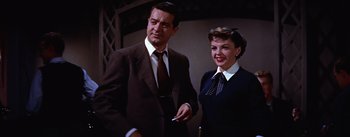 Movie still from “A Star Is Born” (1954), directed by George Cukor – A man and a woman standing next to each other; Medium shot, Low angle