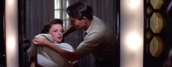 Movie still from “A Star Is Born” (1954), directed by George Cukor – A man and a woman are in a room together; Medium shot, Low angle