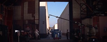 Movie still from “A Star Is Born” (1954), directed by George Cukor – An open door leading to a building with a street light hanging from it's side; Extreme Wide shot, Low angle