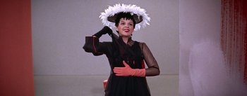 Movie still from “A Star Is Born” (1954), directed by George Cukor – A woman in a black dress and a white feather hat; Medium shot, Low angle