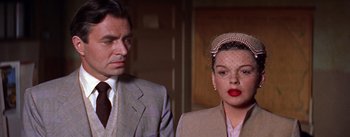 Movie still from “A Star Is Born” (1954), directed by George Cukor – A man and a woman standing next to each other; Close Up shot, Over the shoulder angle