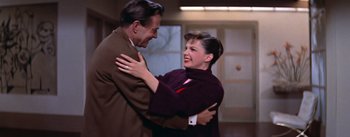 Movie still from “A Star Is Born” (1954), directed by George Cukor – A man and a woman dancing in a room together; Medium shot, High angle